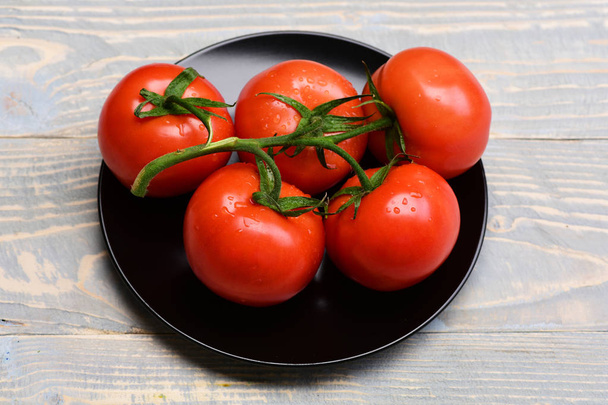 Tomatoes, cherry on vine on on plate, grey vintage background - Foto, Bild
