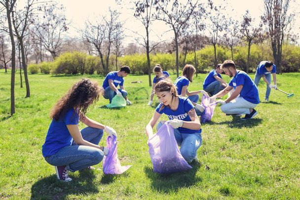 Grupo de jóvenes voluntarios recogiendo basura en el parque
 - Foto, imagen