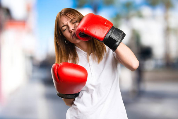 Beautiful young girl with boxing gloves on unfocused background - Foto, afbeelding