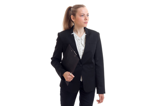 a beautiful young woman in a black business suit looks away and keeps the Tablet - Photo, image