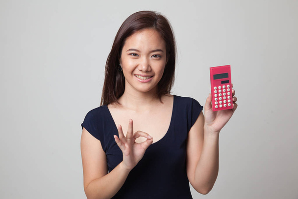 Asian woman show OK with calculator. - 写真・画像