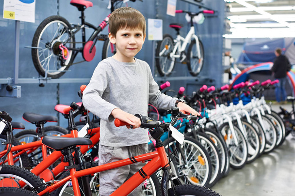 Boy chooses bicycle in sport store - Zdjęcie, obraz