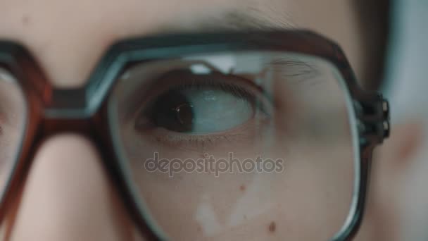 Kaukaski mężczyzna w dużych rogowych okularów brązowe oczy, patrząc z boku na bok - Materiał filmowy, wideo