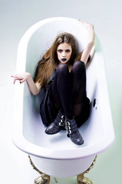 woman in dress with long hair, black lipstick in bath - Photo, Image