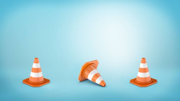 Three striped traffic cones placed on blue background and the middle one lying on its side. - Zdjęcie, obraz