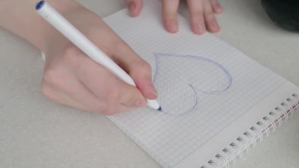 Drawing a heart on a piece of paper - Záběry, video