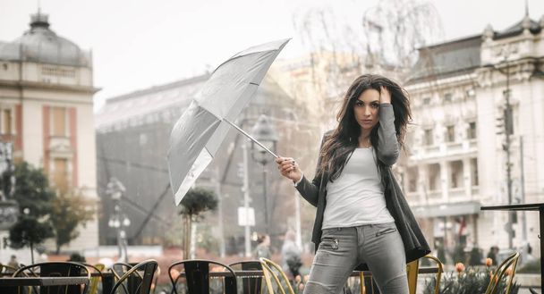 Женщина с зонтиком под дождем на городской улице
 - Фото, изображение