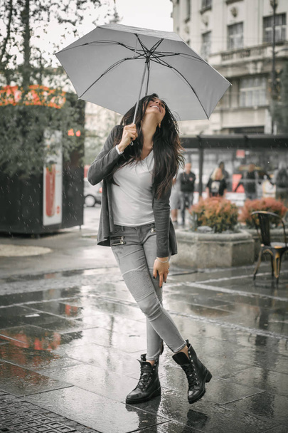 Heureuse femme souriante sous le parapluie sous la pluie
 - Photo, image