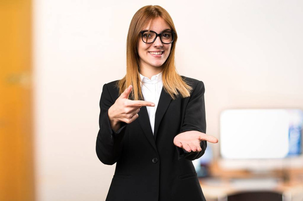 Young business woman holding something in the office on unfocused background - Photo, Image