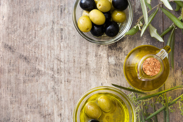 Virgin olive oil in a crystal bottle on wooden background - Foto, Bild
