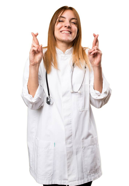 Young doctor woman with her fingers crossing - Photo, Image