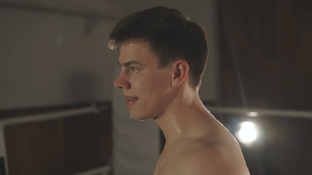 Close-up handsome kickboxing man training hits in the boxing studio - Felvétel, videó