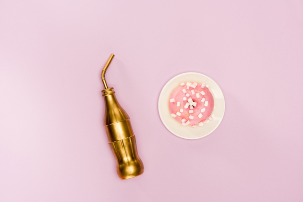 Donut en glaseado rosa y botella de oro
 - Foto, Imagen