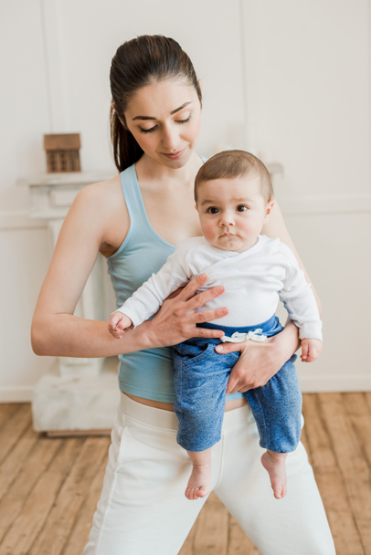 Frau trägt Baby auf dem Arm - Foto, Bild