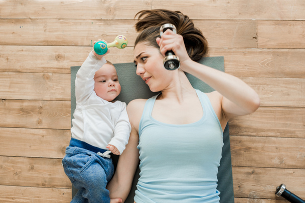 mother and baby boy playing with dumbbells  - Foto, Bild