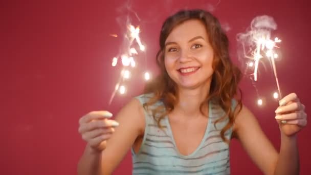 Beautiful smiling woman dancing with a sparkler - Video, Çekim