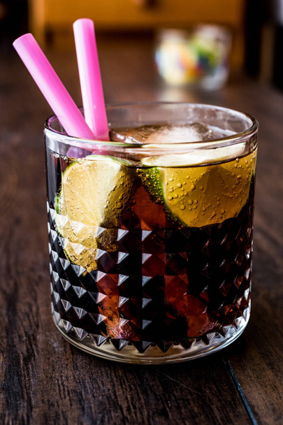 Whiskey Cola Cocktail with lime and ice. (cuba libre) - Fotoğraf, Görsel