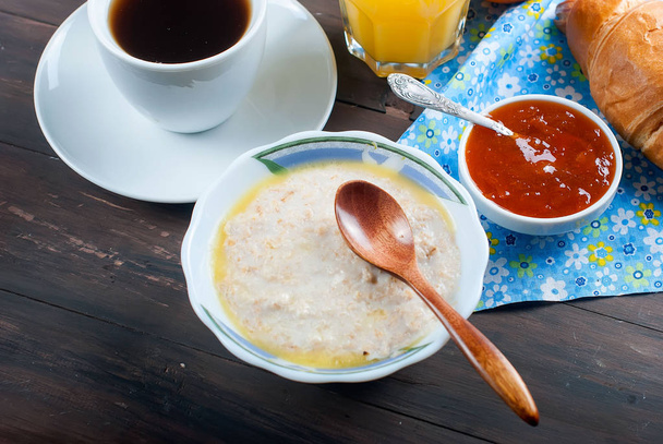 Healthy breakfast with oatmeal with butter,croissant, and coffee - Photo, Image