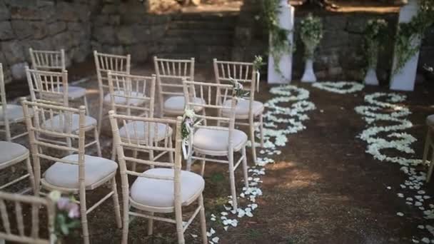 Καρέκλες σε γαμήλια τελετή. Διακοσμημένα με Ανθοσυνθέσεις - Πλάνα, βίντεο