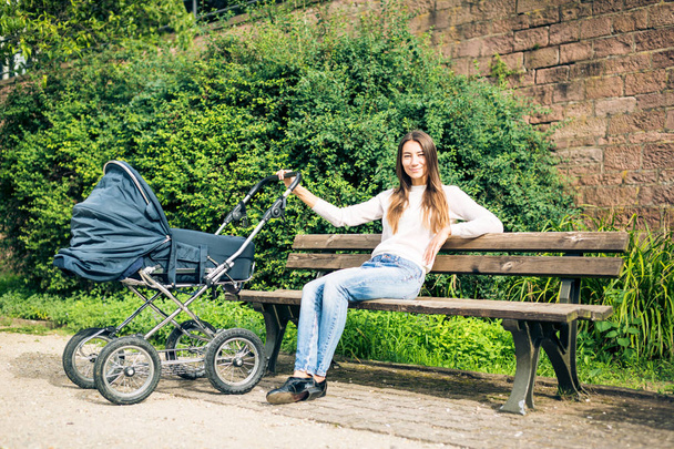 Young Mother With Baby Stroller In The Park - Fotografie, Obrázek