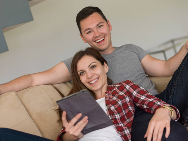 casal relaxante em casa com computadores tablet
 - Foto, Imagem