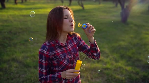 Woman blowing soap bubbles outdoors - slow motion - Footage, Video