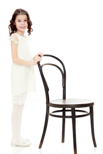 Slender little dancer posing near the old Vienna chair. - Фото, зображення