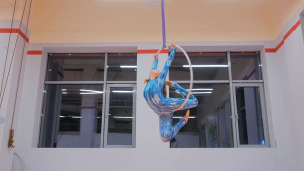 Kunststof mooi meisje gymnast op acrobatische circuspiste - Foto, afbeelding