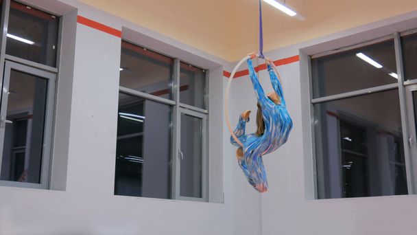 Пластикова красива дівчина-гімнастка на акробатичному цирковому кільці
 - Фото, зображення