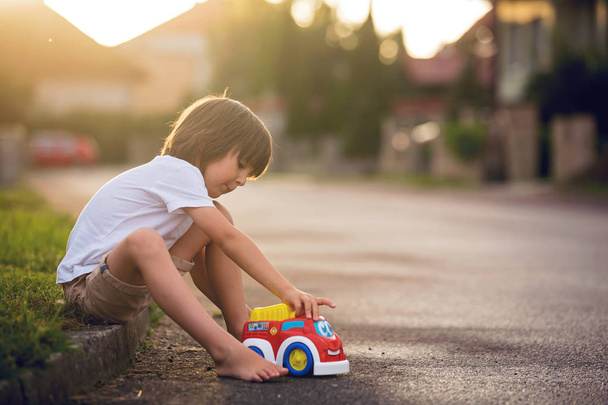 Cute sweet child, boy, playing with car toys on the street in vi - Фото, зображення