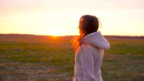Vrouw loopt door een breed terrein bij zonsondergang - Video