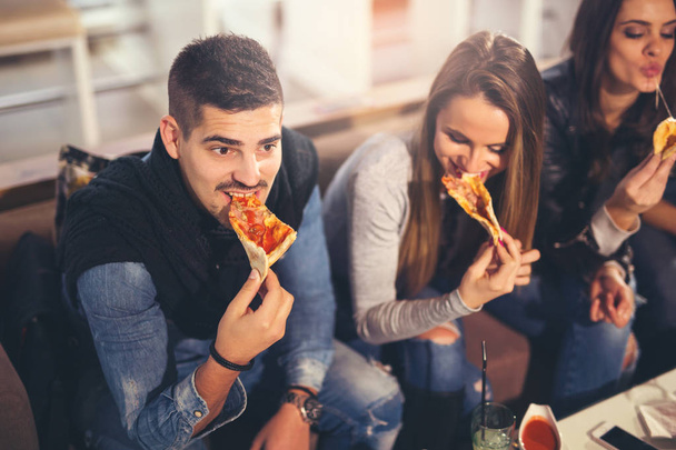 Giovani alla moda che mangiano pizza
 - Foto, immagini