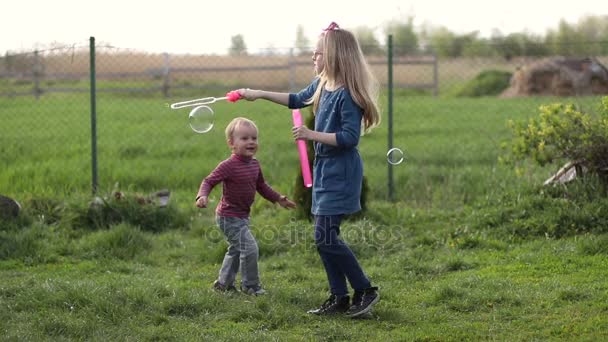 Feliz lindo niños jugando con burbujas en el patio
 - Imágenes, Vídeo