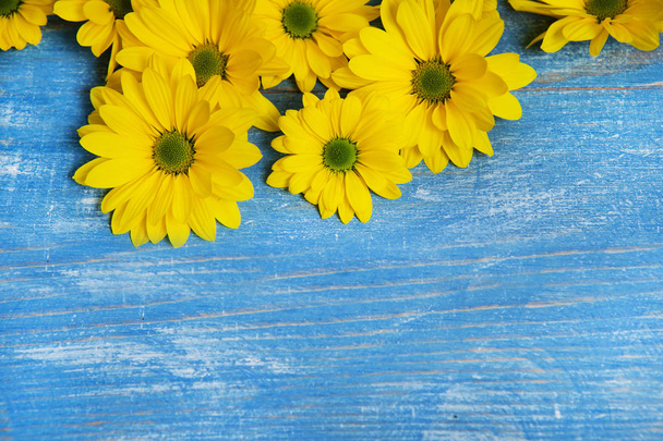 Gartenblumen über bemaltem Holztischhintergrund. Hintergrund mit Kopierraum. schöne Blumen auf hölzernem Hintergrund, blumigem Hintergrund, Blumenrand. - Foto, Bild