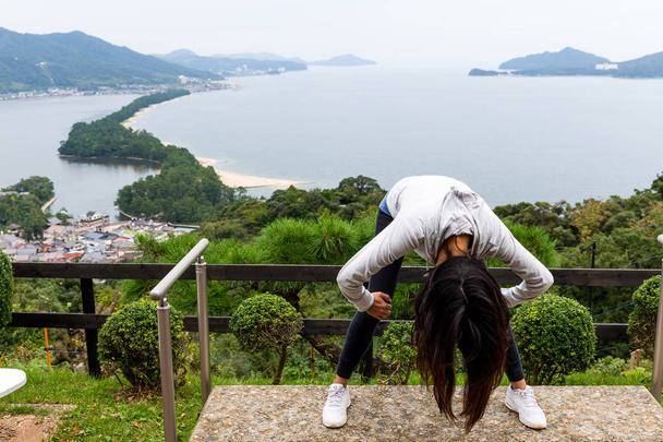 Vrouw opwaartse omlaag en bekijken van Amanohashidate  - Foto, afbeelding