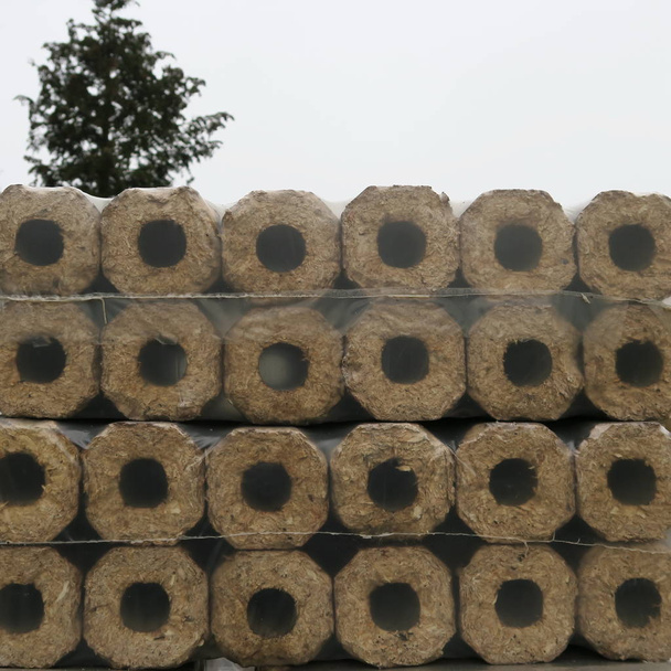 Wooden briquettes wrapped in foil, delivered to heat in winter - Photo, Image