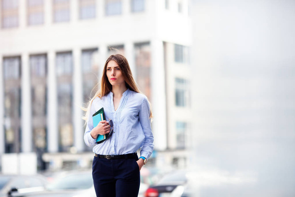 Successful businesswoman with Notepad while walking outdoor. City business woman working. - Foto, afbeelding