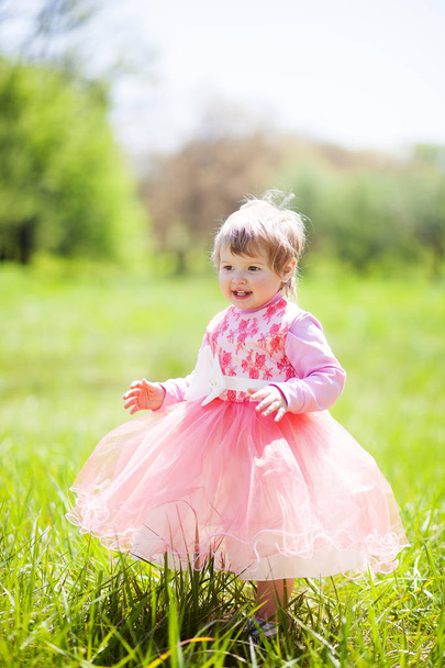Schattige babymeisje 1-2 jaar oud in fancy dress in het Park. Portret van schattig klein vrolijk meisje buiten op warme en zonnige zomerdag - Foto, afbeelding