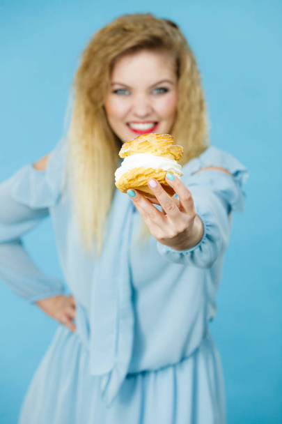 Funny woman holds cream puff cake - Фото, зображення
