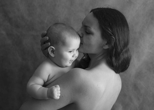 Retrato preto e branco da mãe com o bebê a mãos
 - Foto, Imagem