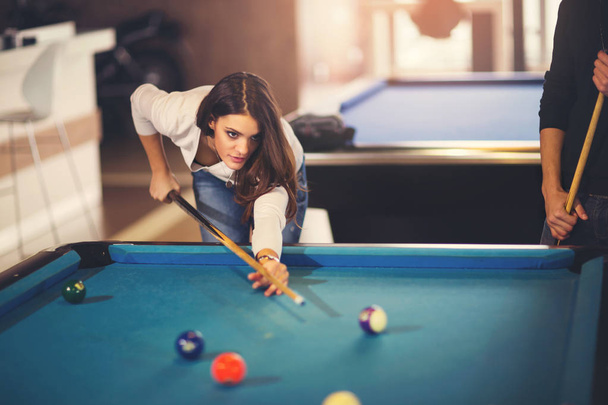 Young beautiful young woman aiming to take the snooker shot whil - Photo, Image