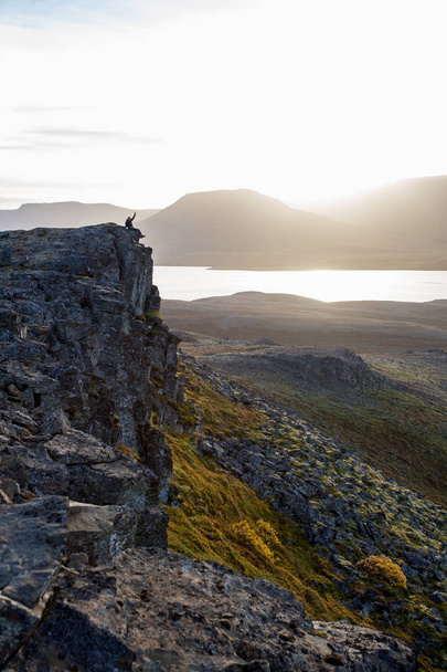 夕日の中に岩の崖にハイカー。素敵な雰囲気  - 写真・画像