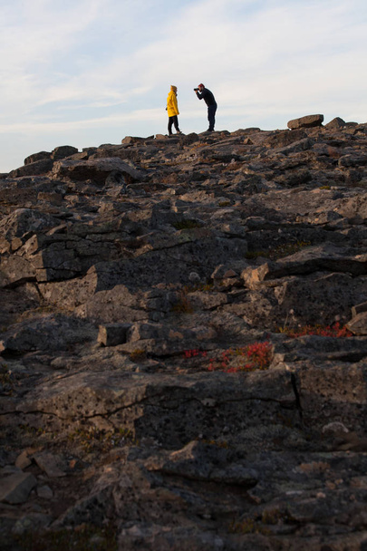 Photographer and hiker on a rocky cliff during the sunset. Great - Foto, immagini