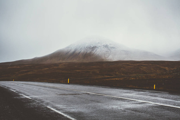 Empty road in front of a mountain range with fog. Lovely landsca - Valokuva, kuva