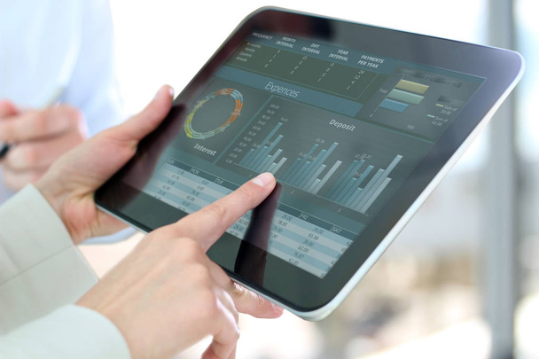 businesswoman showing graphs by finger at the digital tablet - Photo, Image