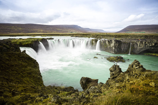Холодная вода в Исландии. Водопад Годафосс в скалистых горах. Fr
 - Фото, изображение