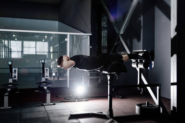 Nuori mies treenaa selkälihaksia. Lihaksikas urheilija kuntoilee. Koko kehon pituus muotokuva
 - Valokuva, kuva