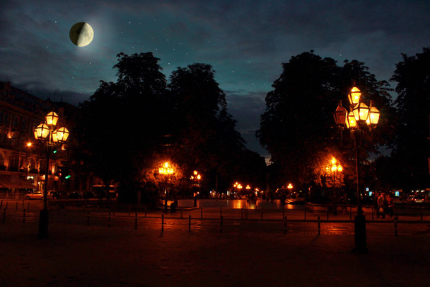 Το φεγγάρι με λαμπερά αστέρια πάνω από την πόλη το βράδυ - Φωτογραφία, εικόνα