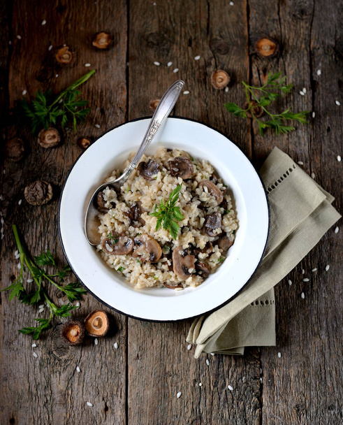 Risotto with mushrooms on an old wooden background. Rustic style. - Photo, Image