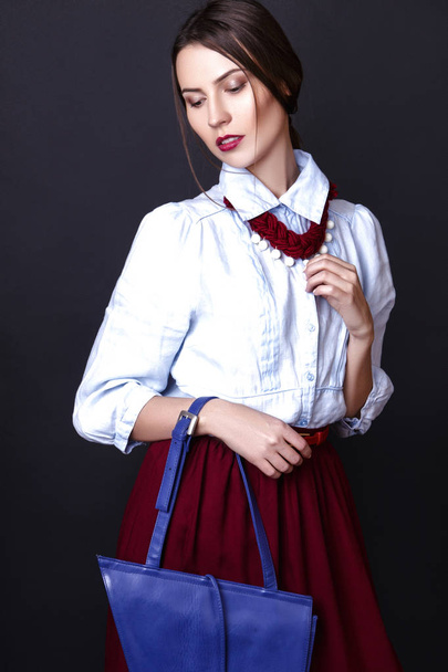 Elegant girl in denim blouse and red skirt in studio on white background - 写真・画像